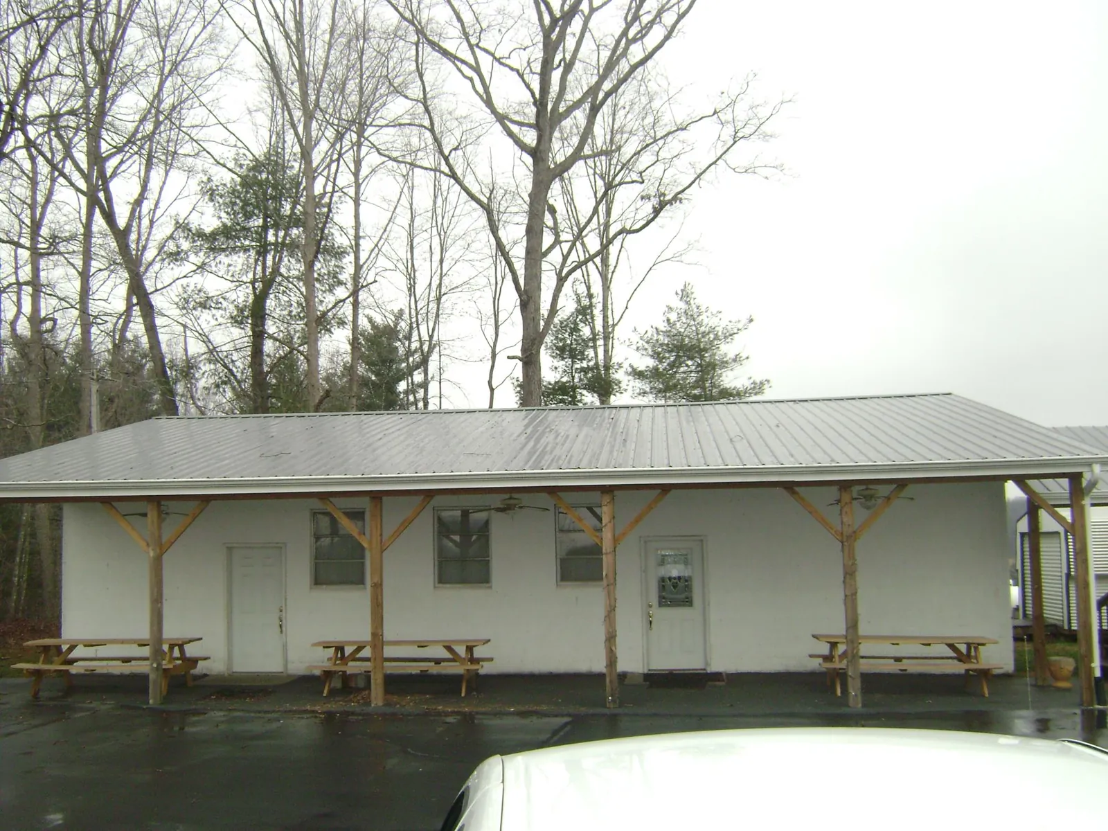 Gray metal roof over a block building with a timber post porch in Bethel
